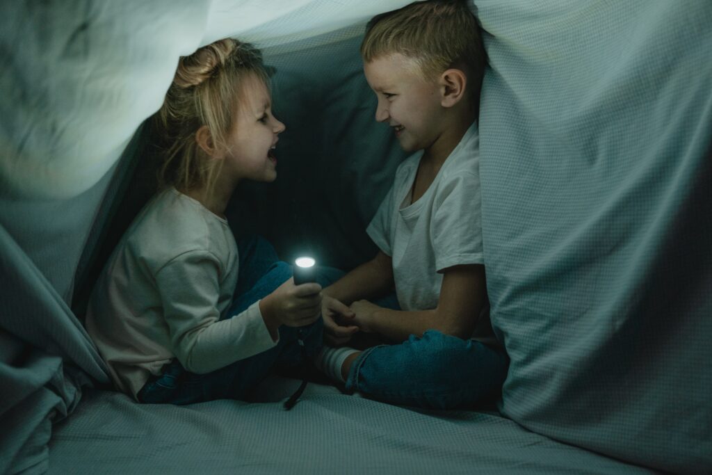 two kids playing in a pillow fort